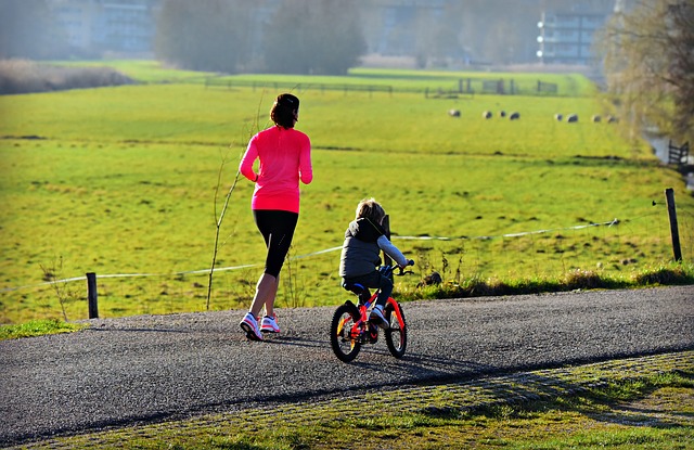běžící matka s dítětem na kole